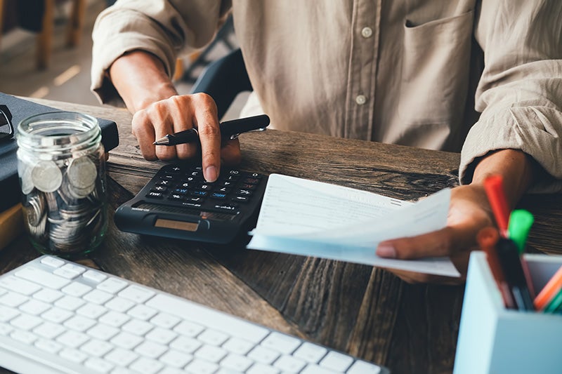 Person at desk with calculator